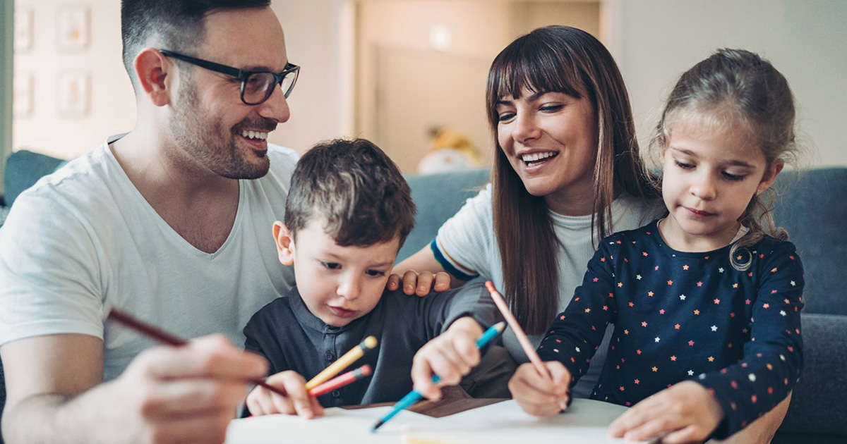 Photo of family coloring with their kids.